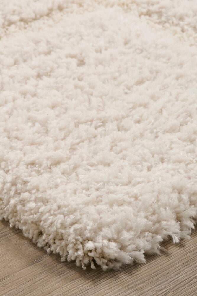 En mjuk vit ryamatta på trägolv.