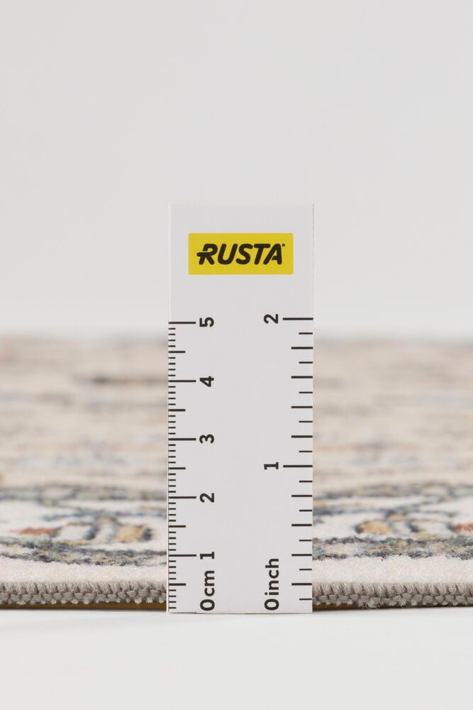 Lähikuva beigestä kuviollisesta polyamidimatosta Erna, paksuus ja rakenne näkyvät viivaimen kanssa.