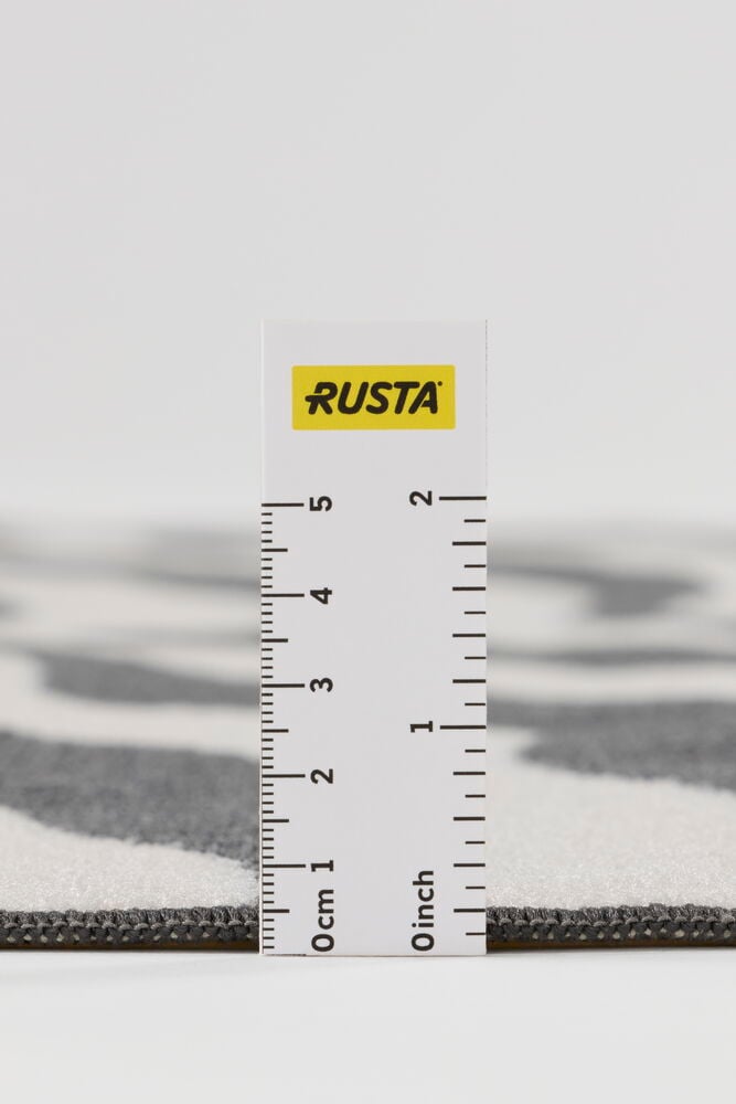 Lähikuva graniitinharmaasta Polyamidi Matto Zebrasta, jossa valkoinen abstrakti kuvio, esillä mittaviivaimen kanssa.