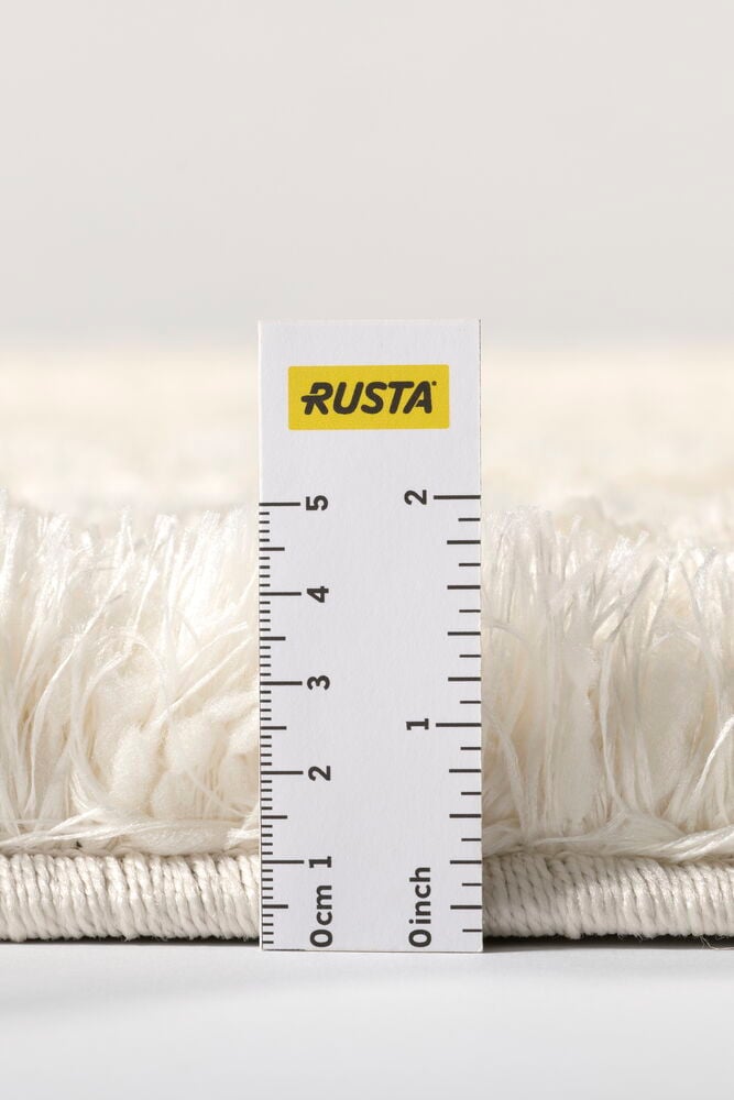 Lähikuva Kerma pörrömatosta sivulta mittatikun kanssa, näyttäen sen paksuuden.