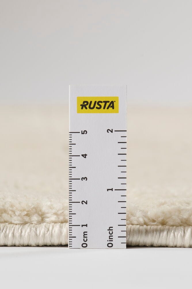Lähikuva Kerma karvalankamatosta, jonka paksu nukka on mitattu noin 3 cm valkoisella viivaimella.