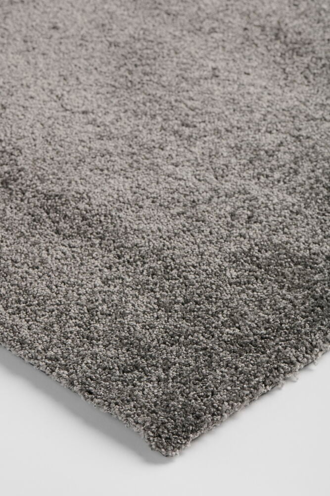 Ein dunkelgrauer Läufer aus Polypropylen mit hochfloriger Textur ist auf weißem Untergrund zu sehen.