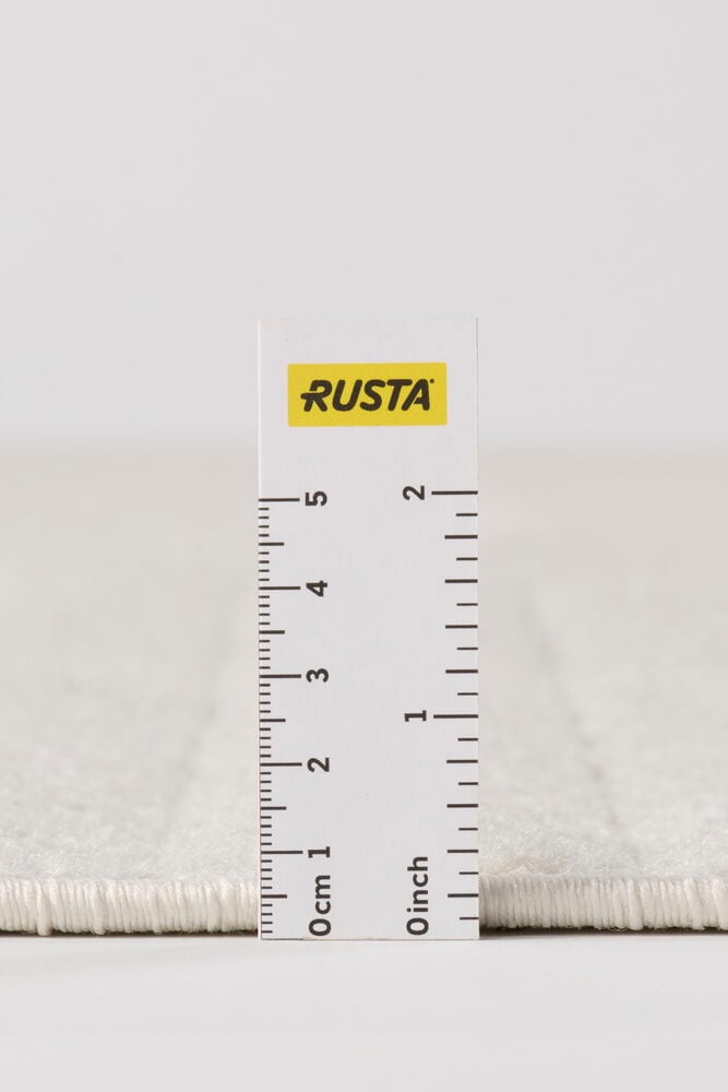 Lähikuva luonnonvalkoisesta polypropeenimatosta Käytävämatto Billie, paksuus mitattuna viivaimella.