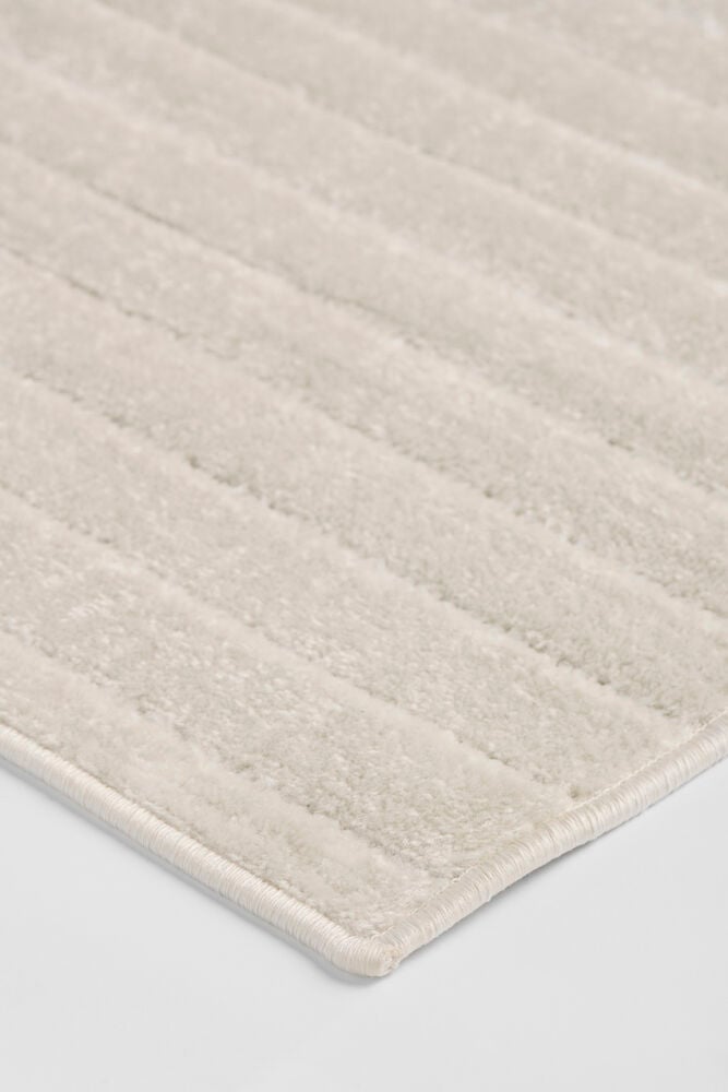 Luonnonvalkoinen Polypropeeni Käytävämatto Billie, lähikuvassa uurretulla kuviolla ja ommellulla reunalla.