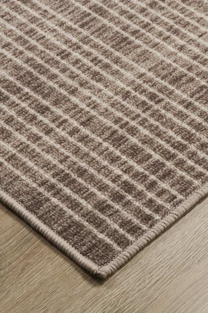 Ruskea käytävämatto, jossa on graafinen kuvio lattiassa.