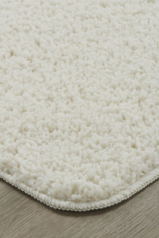 Valkoinen käytävämatto, jossa on pehmeä nukka puulattialla.