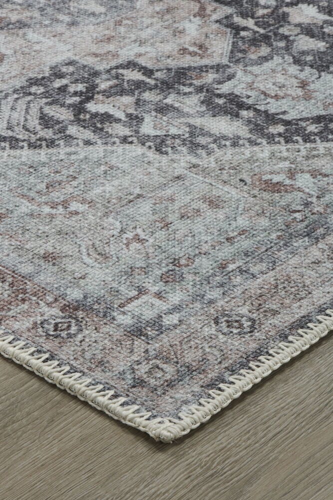 Hörnet av en multifärgad gångmatta på trägolv.