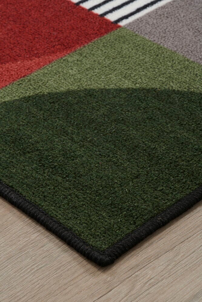 Kulman monivärisestä matosta puulattialla.