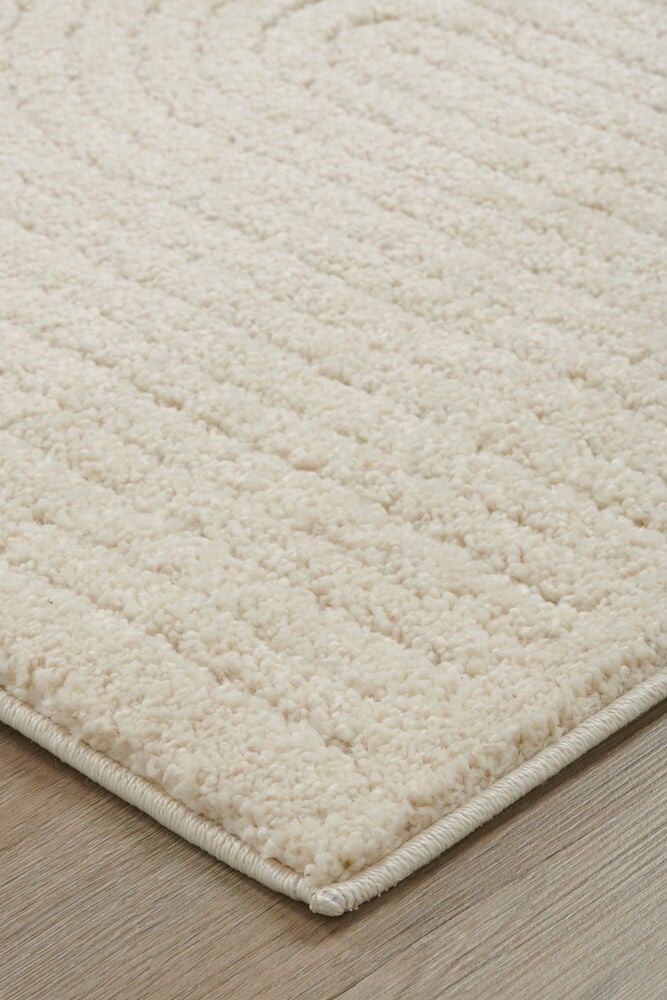 Offwhite gångmatta med diskret mönster på trägolv.