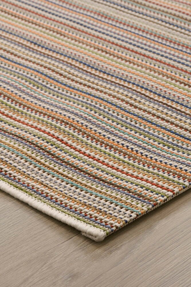 Slätvävd multifärgad matta ligger på trägolv.