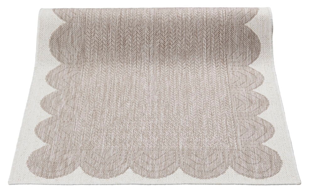 Beige sileä kudottu käytävämatto aaltoilevilla reunoilla.