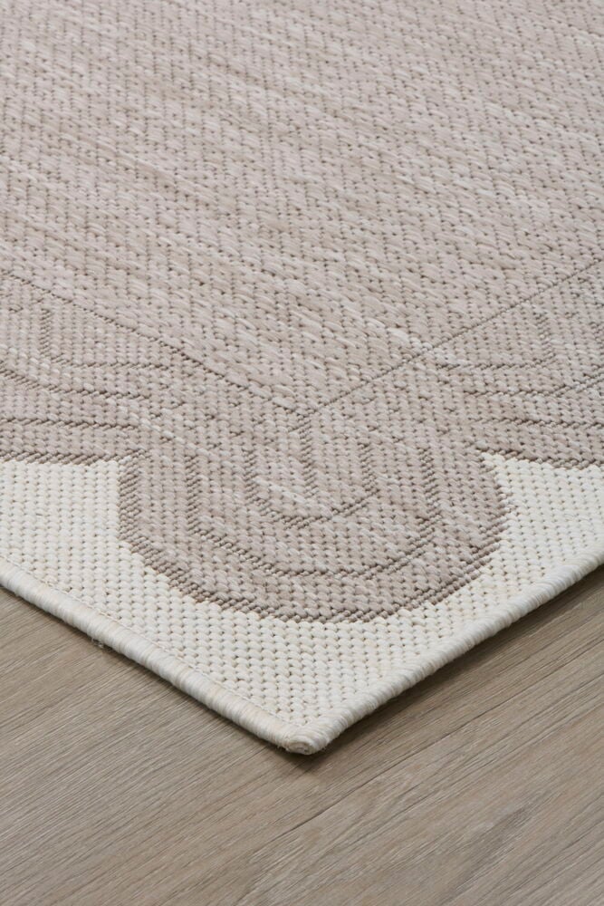 Beige slätvävd gångmatta med mönster på trägolv.