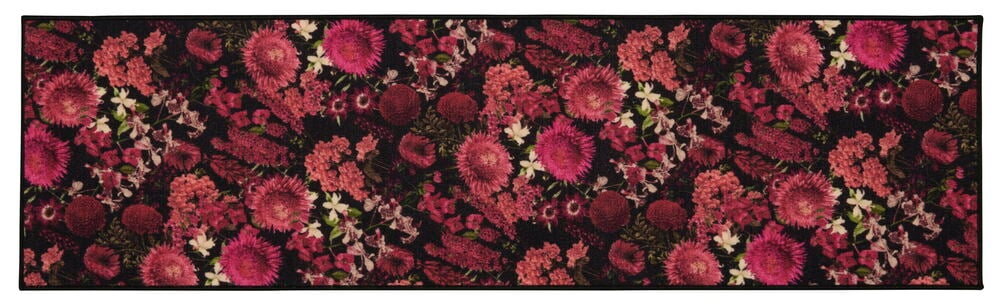 Svart matta med rosa blommönster och grönska.