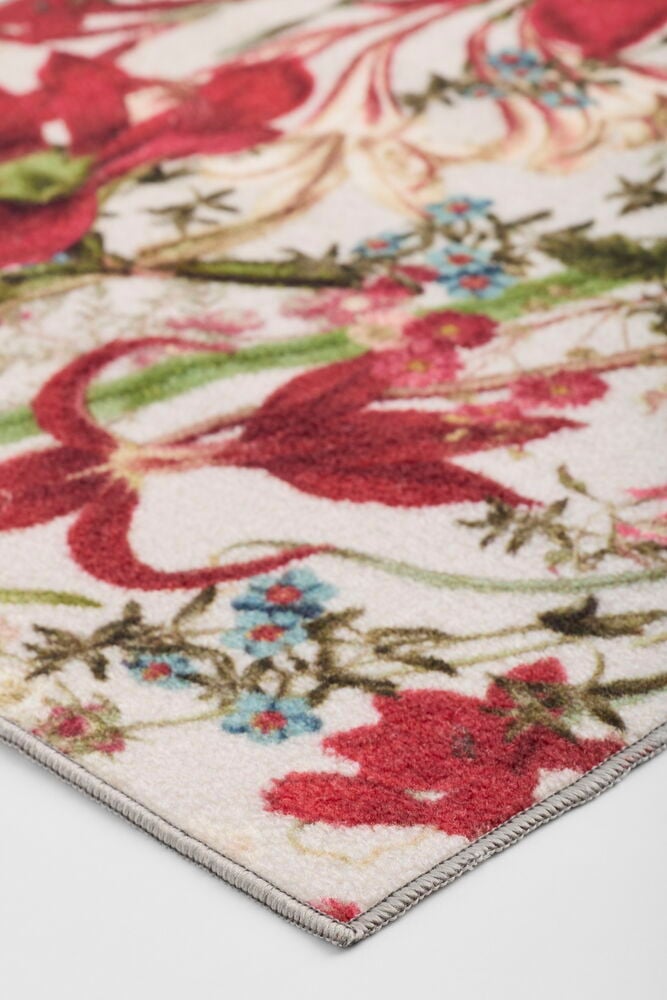 Läufer Noelle, ein naturfarbener Polyamid-Teppich mit leuchtendem rot-blauem Blumenmuster, schräg gezeigt.