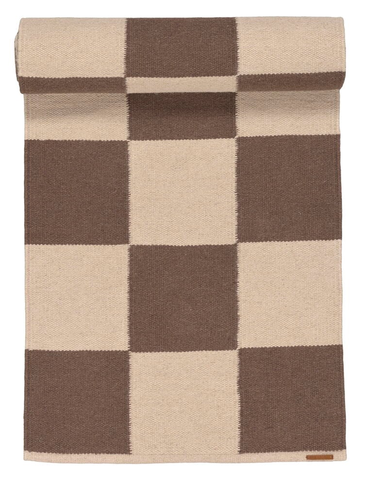 Ruskea ja beige ruudullinen villakäytävämatto, osittain rullattuna.