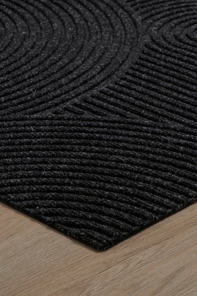 Mörkgrå rektangulär dörrmatta med tuftat mönster.