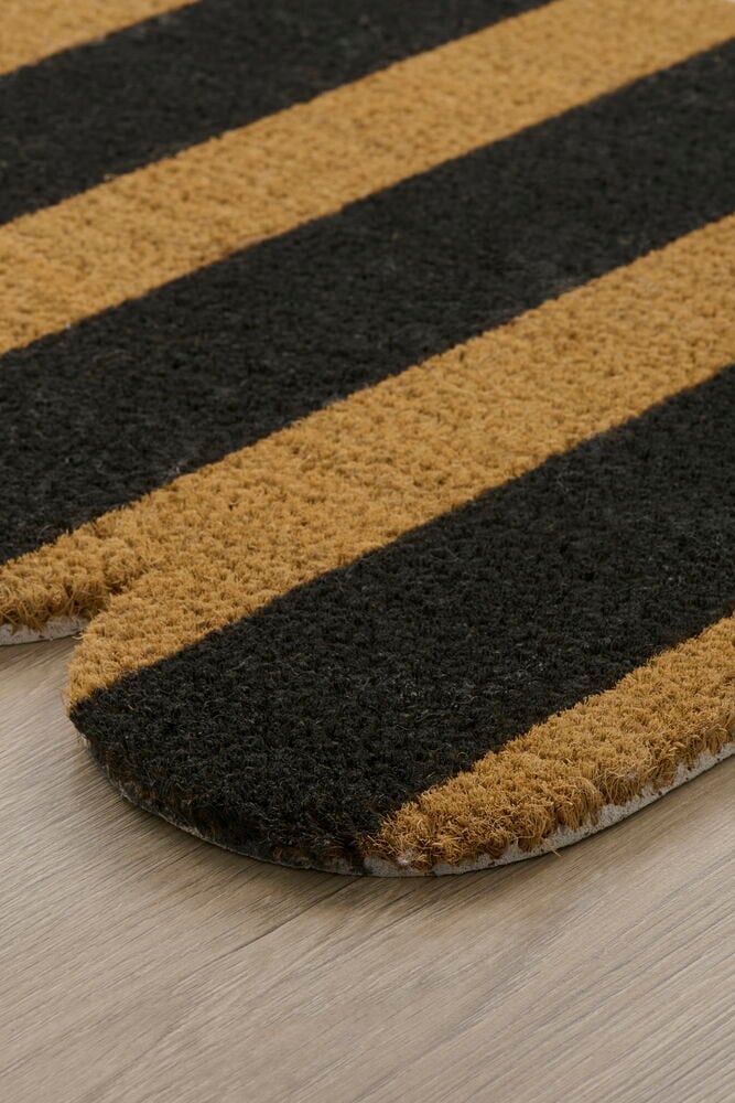 Raidallinen ovimatto kookoskuidusta puulattialla.