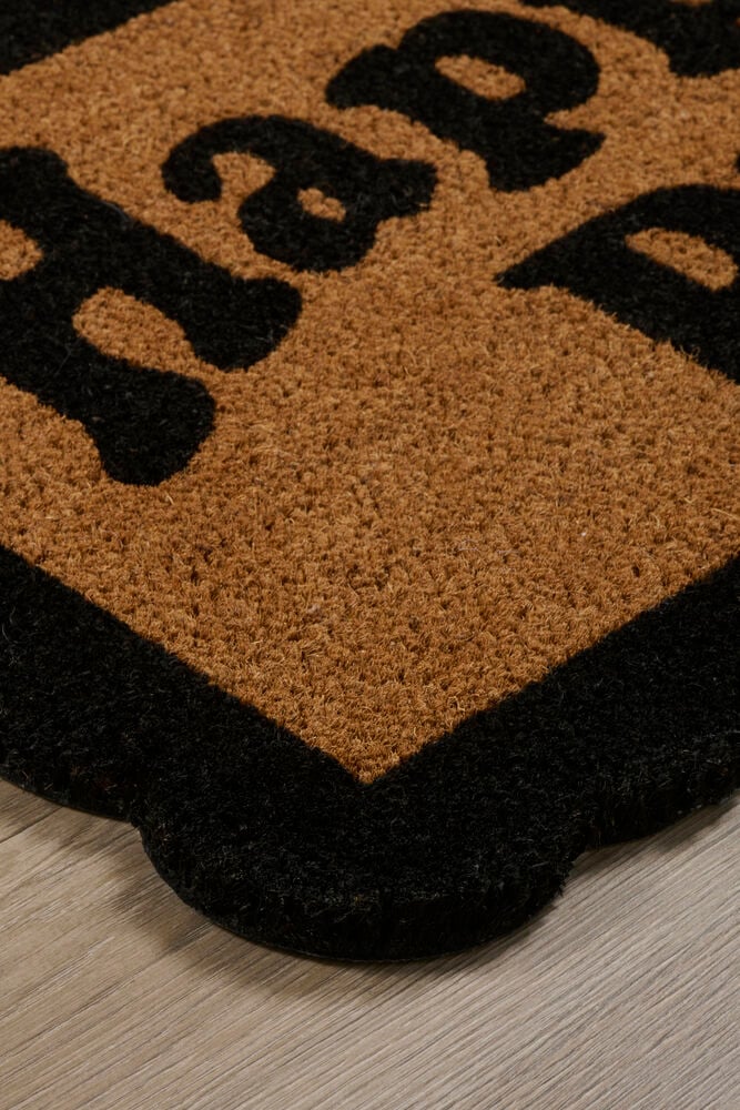 En Svart Kokosfiber dørmatte, brun med svart 'hap'-tekst og bølget kant.
