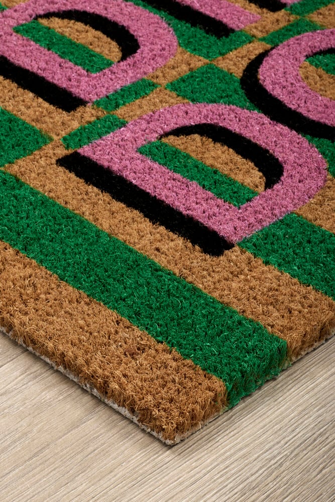 Rosa/Grønn Kokosfiber matte med et geometrisk mønster av rosa former, svarte konturer og grønne striper.
