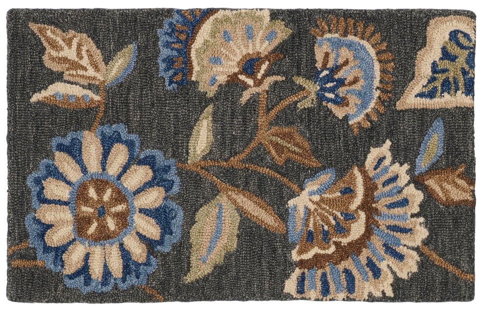 Mørk grå Ullteppe med blått, beige og brunt blomstermønster, ovenfra.
