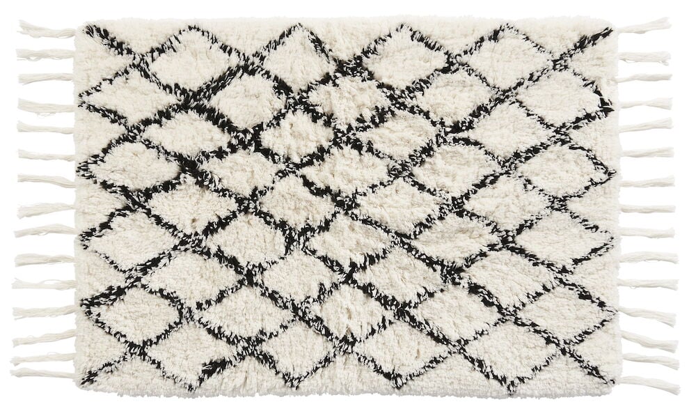Valkoinen ja musta kylpyhuonematto, jossa on kuvio.