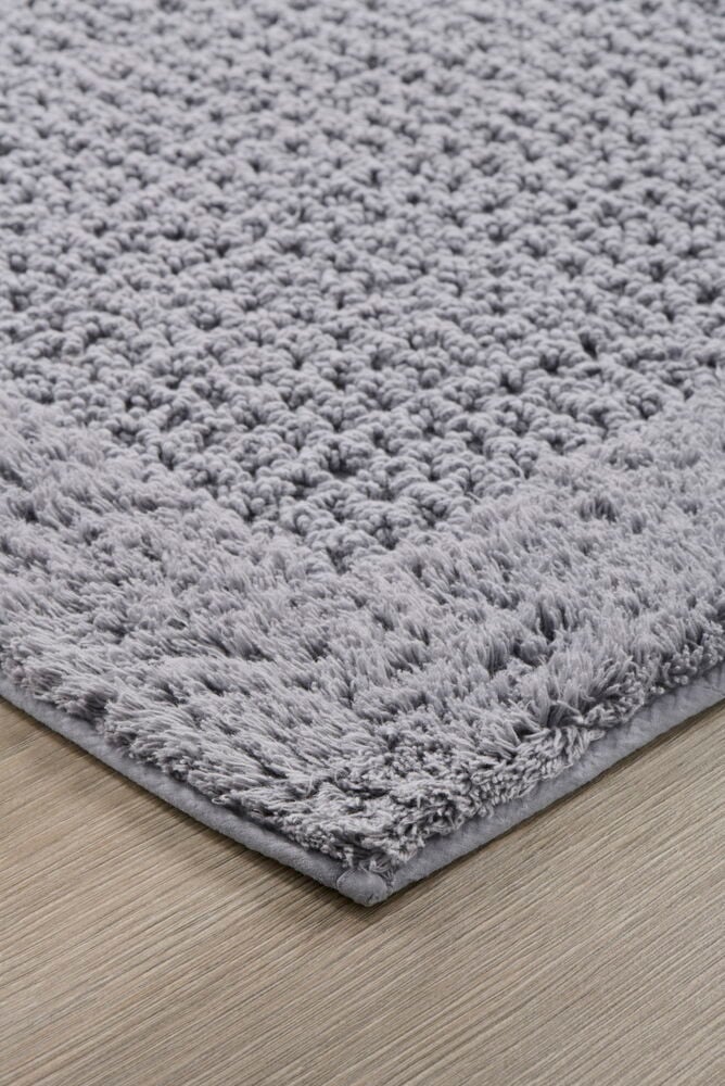 Harmaa suorakulmainen kylpyhuonematto, jossa on rakennekuviointi.