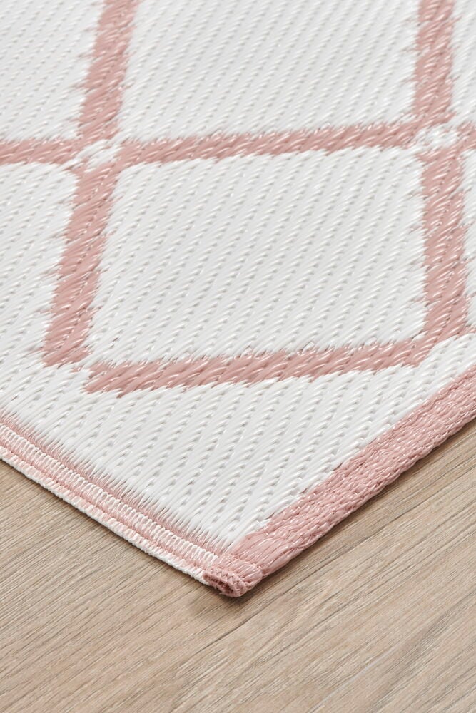 Rektangulär bastmatta med dammrosa och vitt rutmönster.