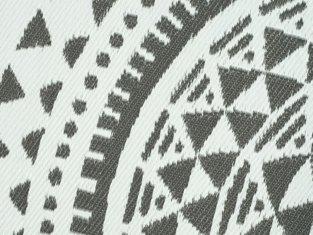 Gråvit bastmatta med geometriskt mönster.