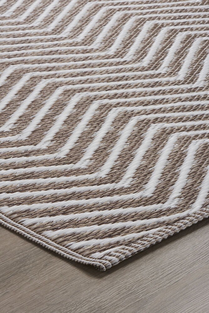 Ljusbrun och vit polypropenmatta med zickzackmönster.
