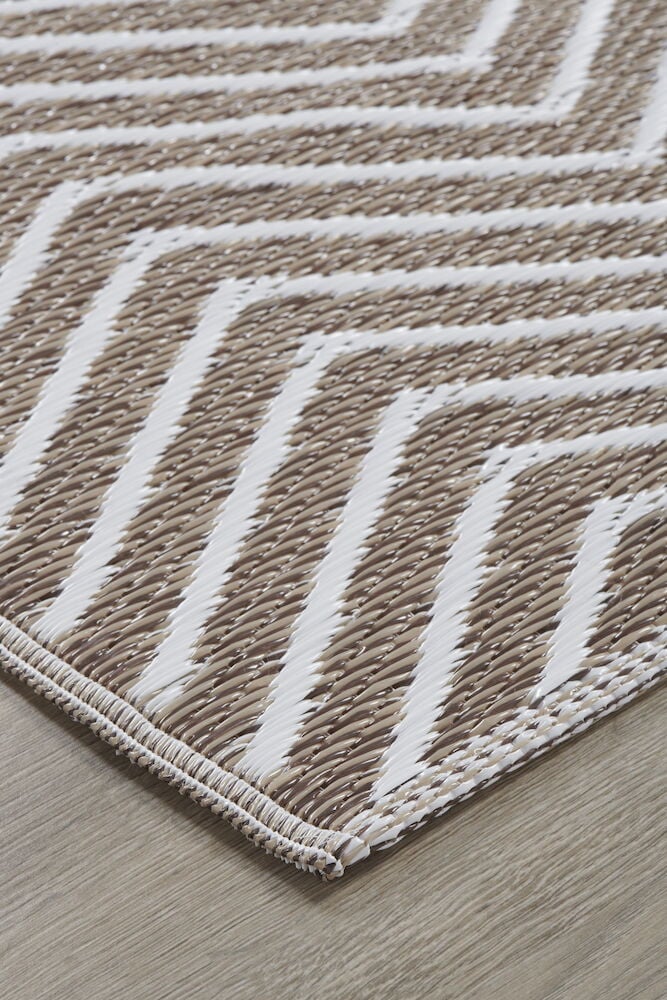 Ljusbrun polypropenmatta med vitt chevronmönster.