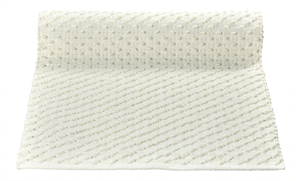 Vit gångmatta med små bollar och texturerad yta.