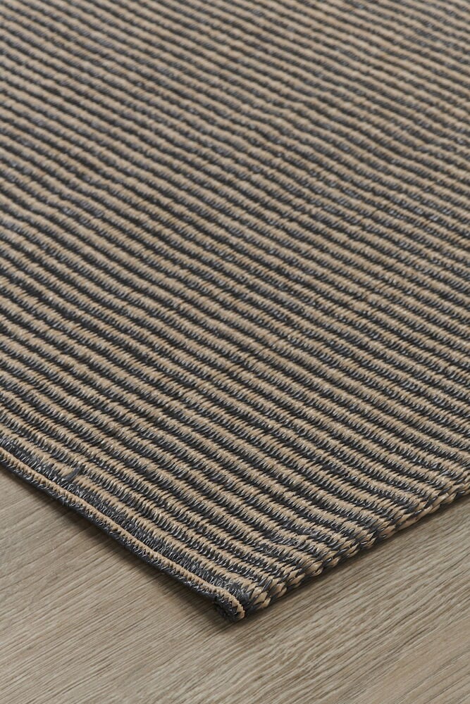 Brun bastmatta med ränder på trägolv.