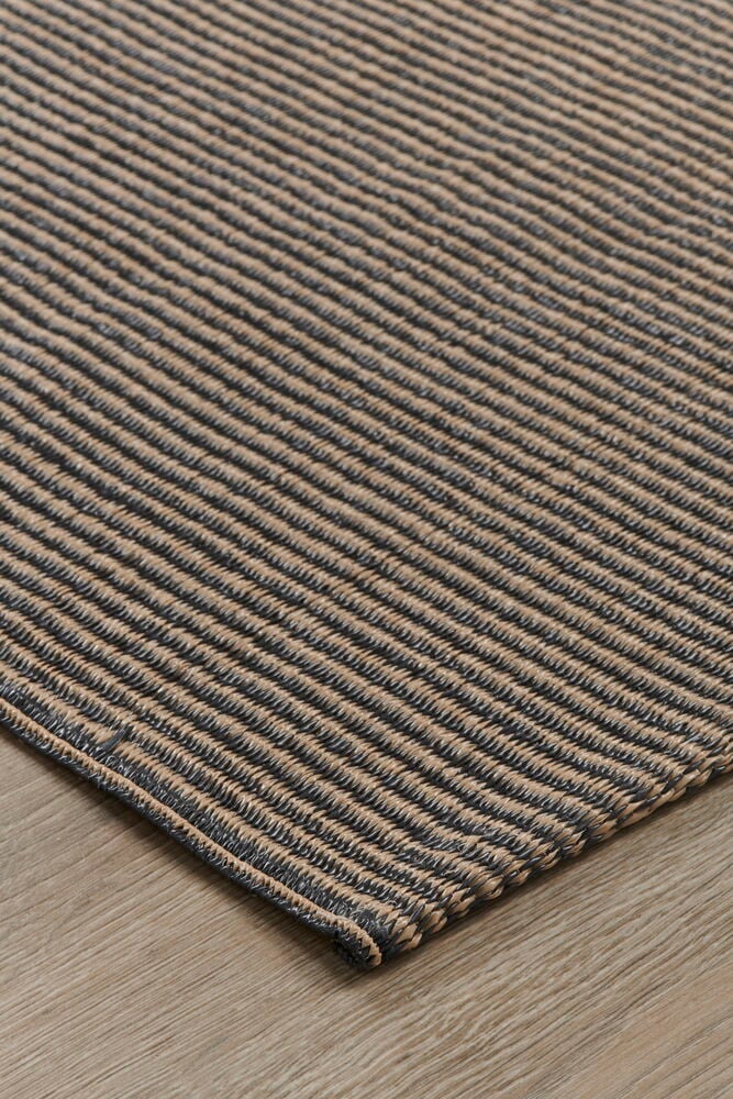 Brun bastmatta med rutmönster på trägolv.