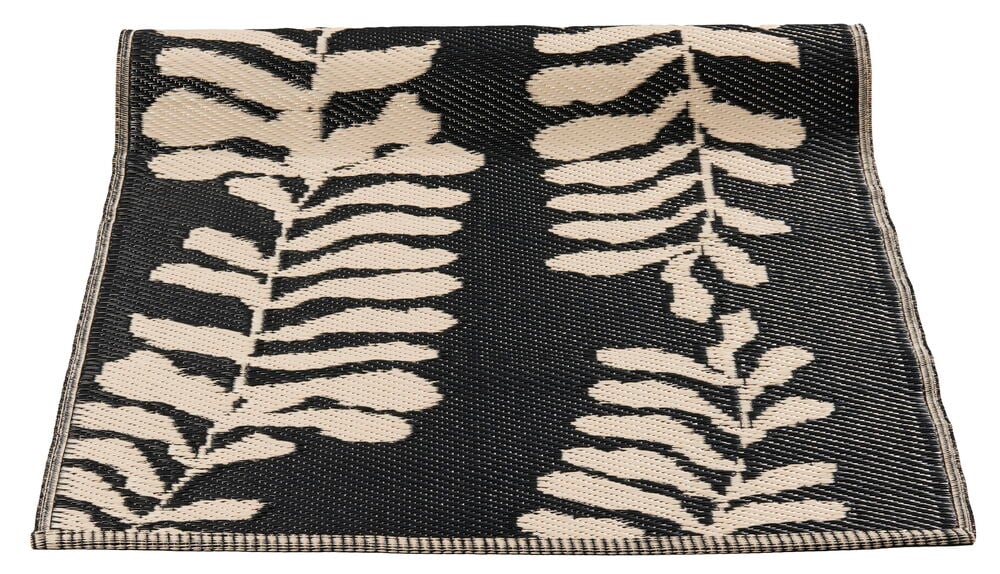 Beige bastmatta med bladmönster på svart bakgrund.