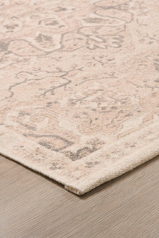 Beige bomullsmatta med dekorativt mönster.