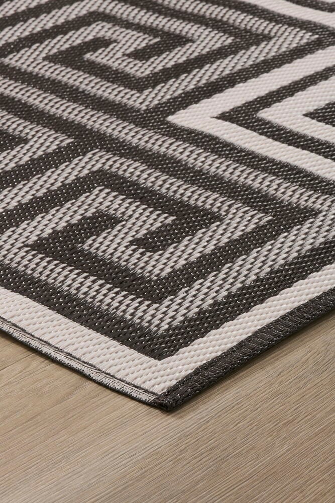 Lähikuva ruskea-valkoisesta geometrisesta Matto Gemma 170x240 cm Polypropeeni -matosta puulattialla.