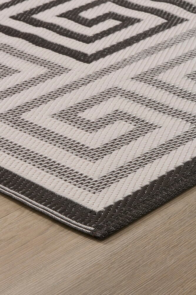 Matto Gemma, tummanharmaa ja valkoinen geometrisella kuviolla, polypropeenista puulattialla.