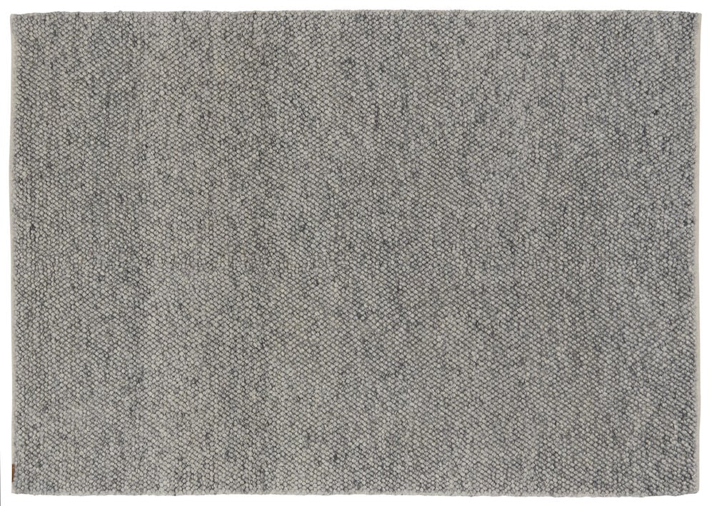 Suuri harmaa käsinkudottu matto meleeratulla pinnalla.