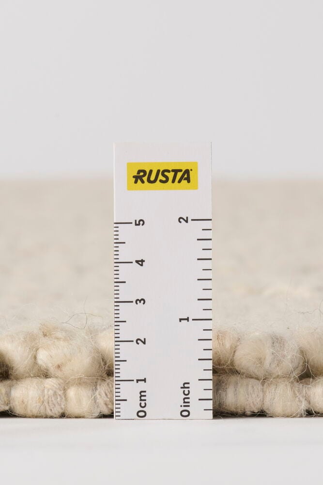 Lähikuva luonnonvärisestä Elsaform Annie villasekoitematosta, viivain näyttää noin 2,5 cm nukankorkeuden.