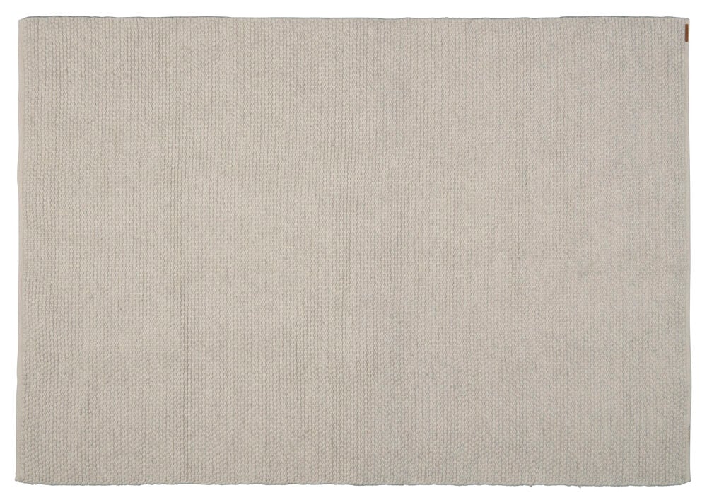 En stor beige handvävd matta i ullblandning.
