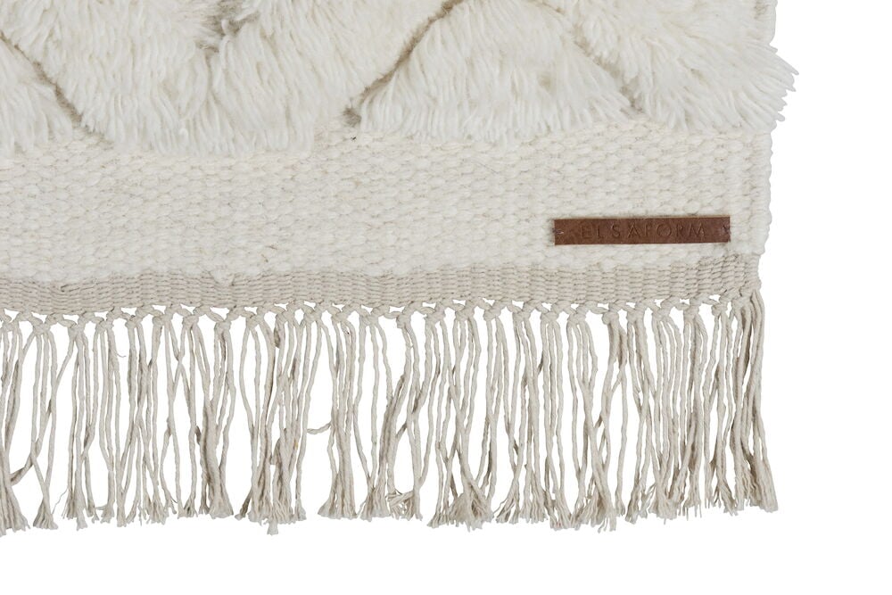 Käsinkudottu luonnonvärinen villamatto hapsuilla ja kuvioilla.