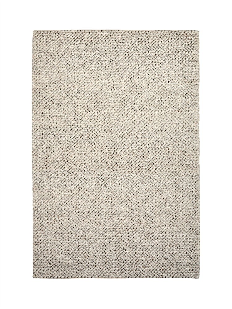 Käsinkudottu luonnonvärinen villamatto, jossa on hillitty kuvio.