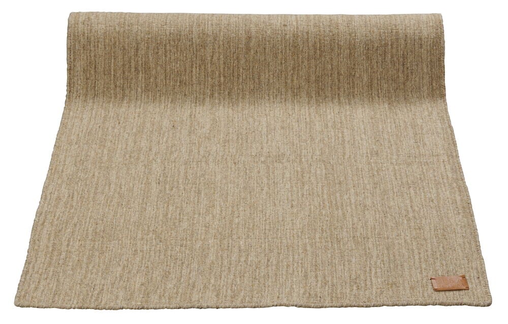 Handvävd brun matta med slät yta och läderdetalj.