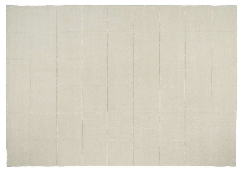 Valkoinen käsinkudottu matto, jossa on heikko ruutukuvio.