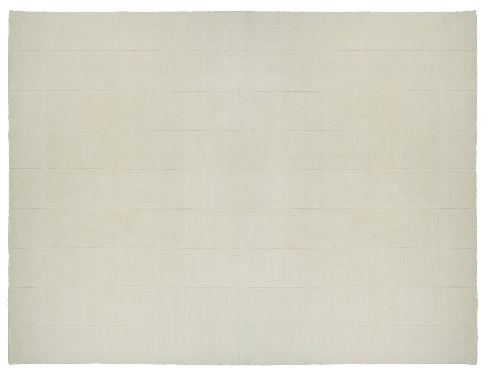 Käsinkudottu valkoinen matto ruutukuviolla.