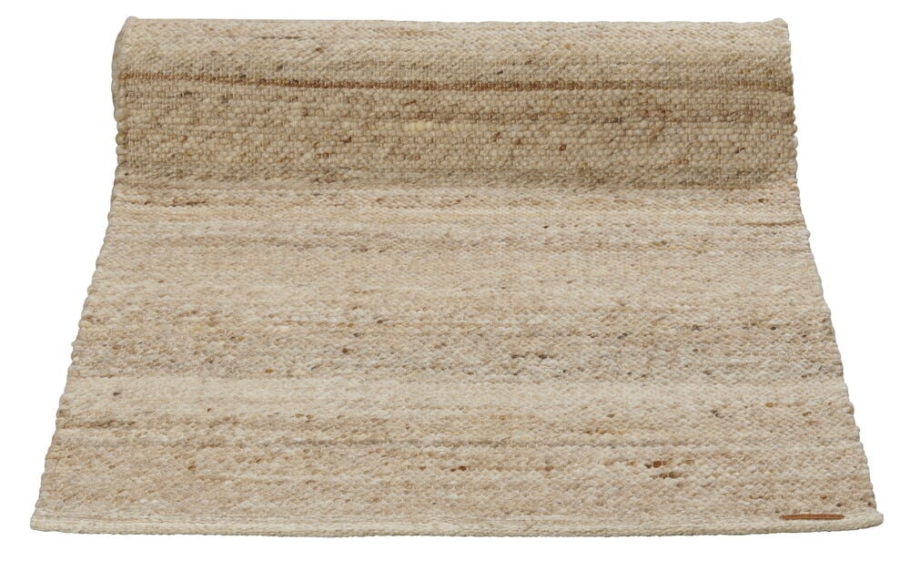 Beige pitkä villamatto meleeratulla kuviolla.