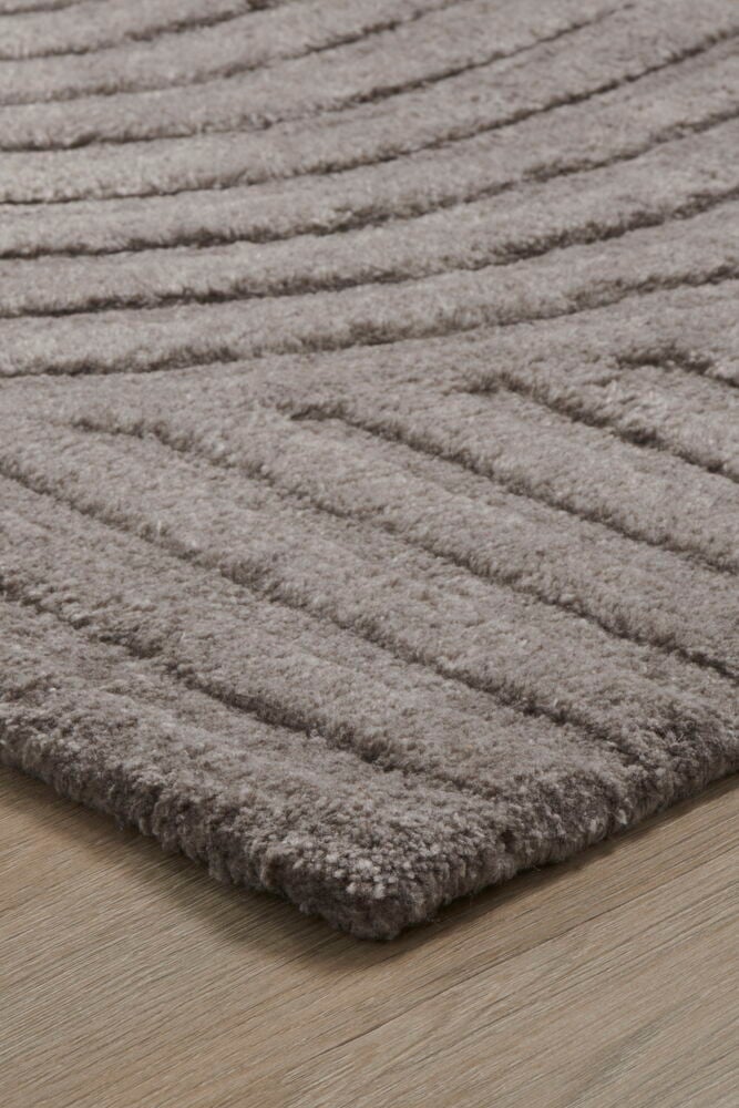 Harmaa ovimatto, jossa abstrakti kaarikuvi lattialla.