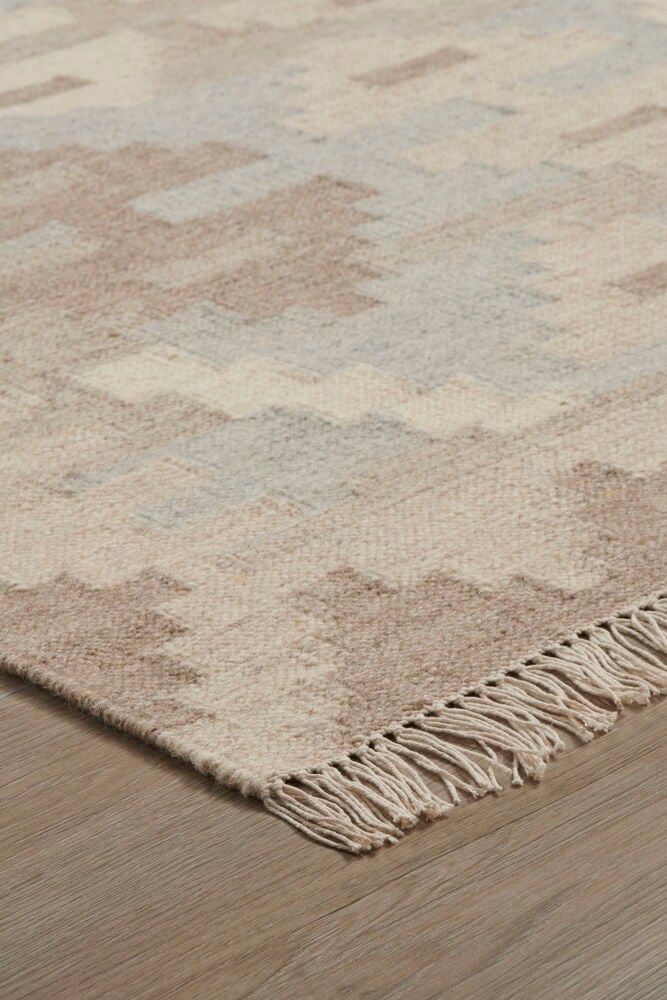 Käsinkudottu villamatto, jossa kelimmuotoilu ja vaaleat hapsut.