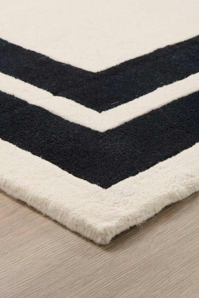 Musta-valkoinen matto, jossa on kaksi leveää raitaa.