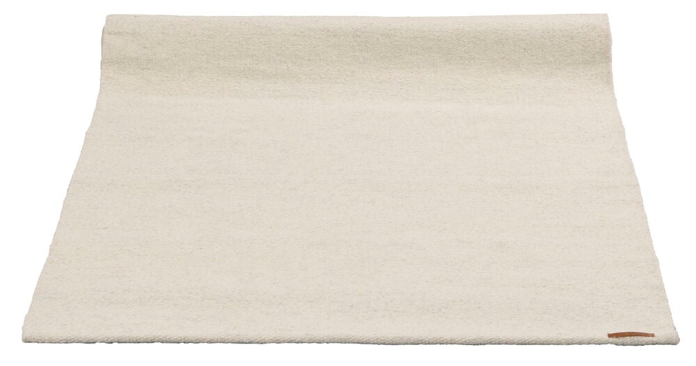 En vikt ljusbeige matta utan mönster.